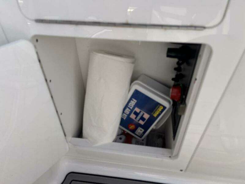 Storage compartment in a 2022 Monterey M-45 boat with paper towels and first aid kit.