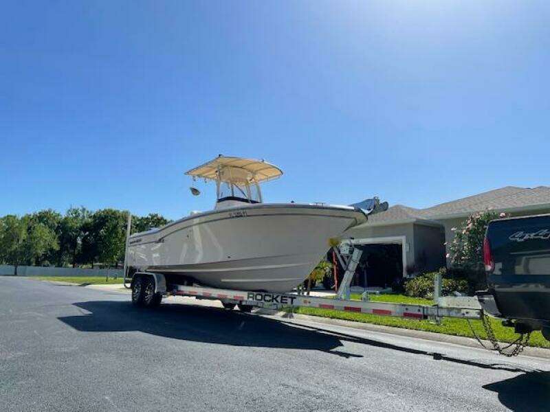 2014 Grady-White Fisherman 257 boat on a trailer in a residential area.
