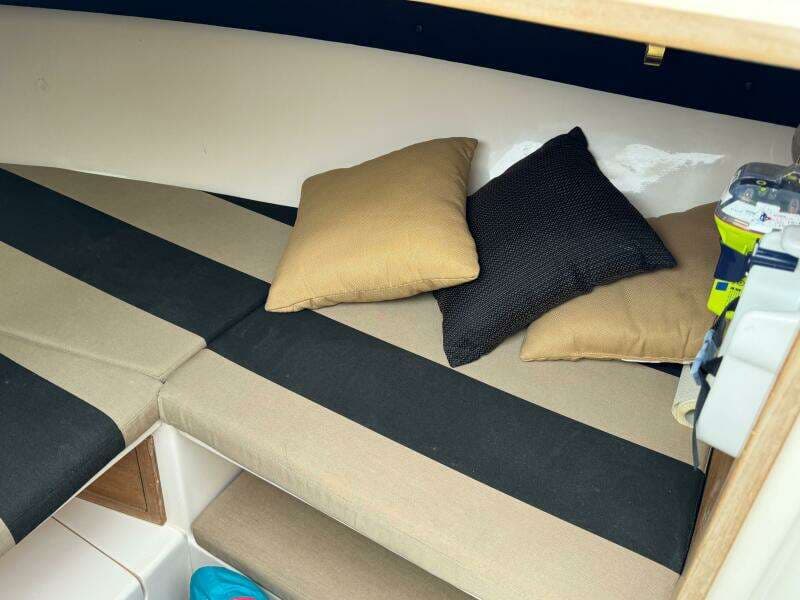 Interior cabin of a 2004 Intrepid 32 Cuddy boat with cushions and pillows.