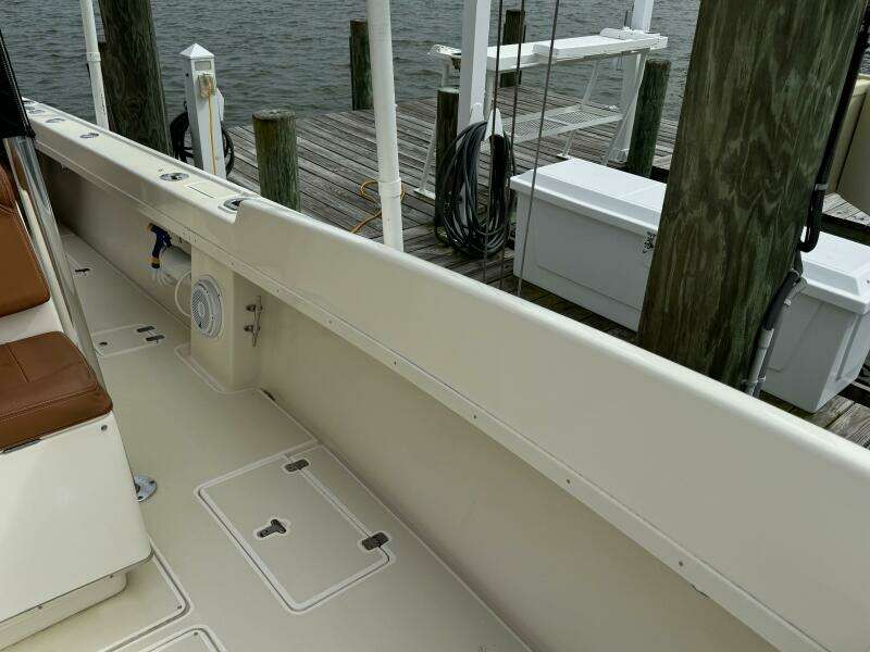 2004 Intrepid 32 Cuddy boat docked, showcasing clean deck and storage compartments.