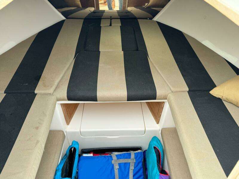 Interior of a 2004 Intrepid 32 Cuddy boat with striped cushions and storage space.