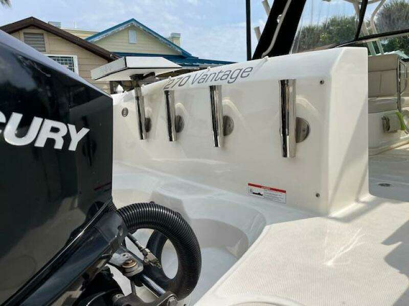 2018 Boston Whaler 270 Vantage boat with Mercury engine, docked near houses.
