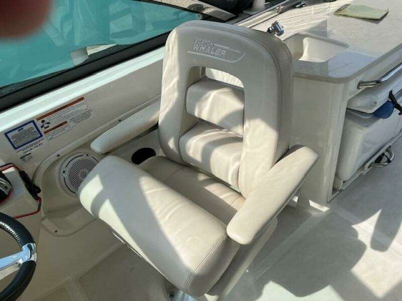 2018 Boston Whaler 270 Vantage captain's chair with armrests and white upholstery.
