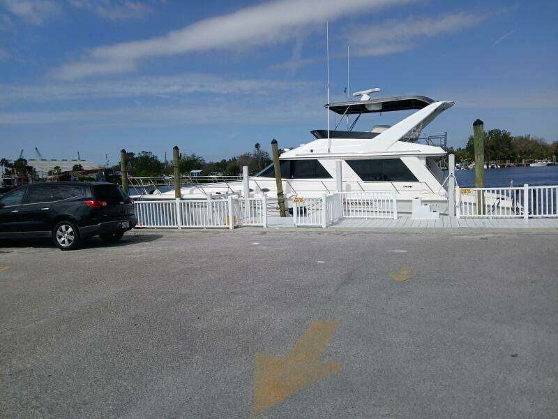 1997 Sea Ray 550 Sedan Bridge yacht docked near a parking lot.