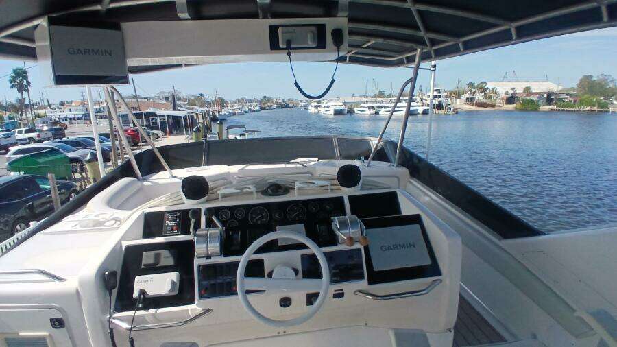 1997 Sea Ray 550 Sedan Bridge helm with Garmin navigation, overlooking marina and waterfront.