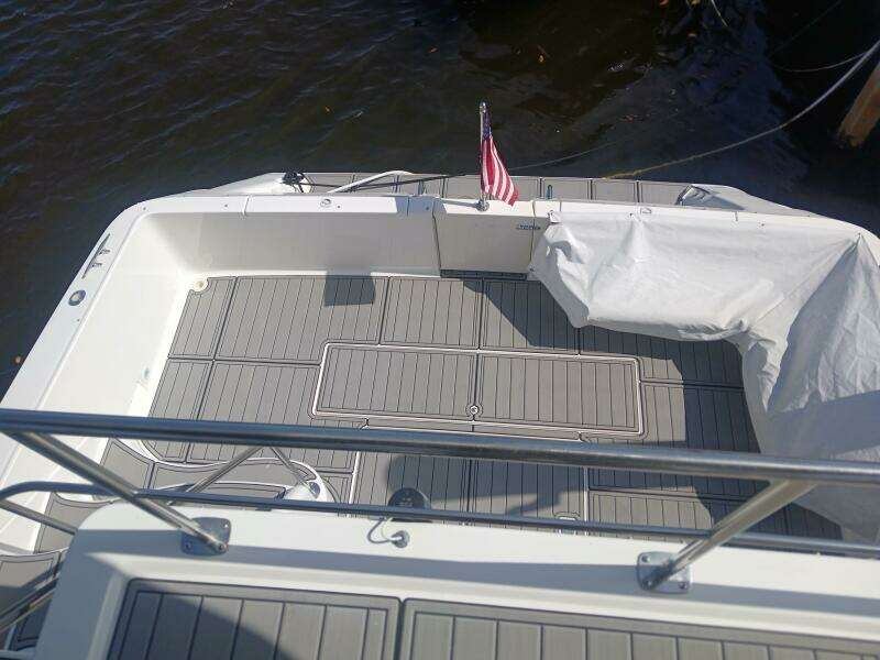1997 Sea Ray 550 Sedan Bridge deck with American flag, docked on calm water.