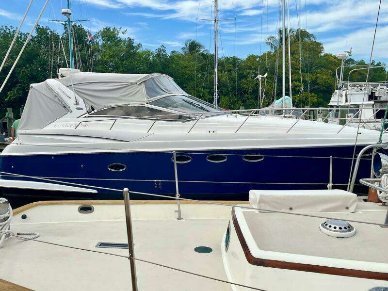 2003 Regal Commodore 3860 yacht docked at marina with blue hull and white cover.