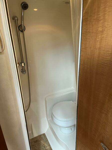 Compact bathroom with shower and toilet in 2003 Regal Commodore 3860 yacht.