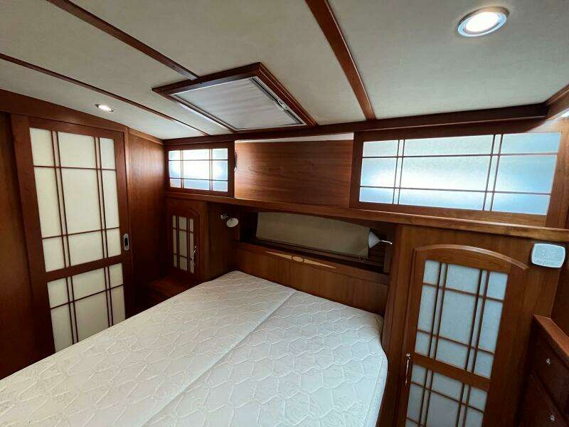 2013 Sabre 48 Salon Express bedroom with wood paneling and frosted glass accents.