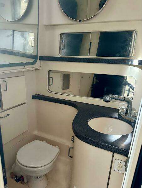 2000 Luhrs Tournament 320 Open bathroom with sink, toilet, and storage cabinets.