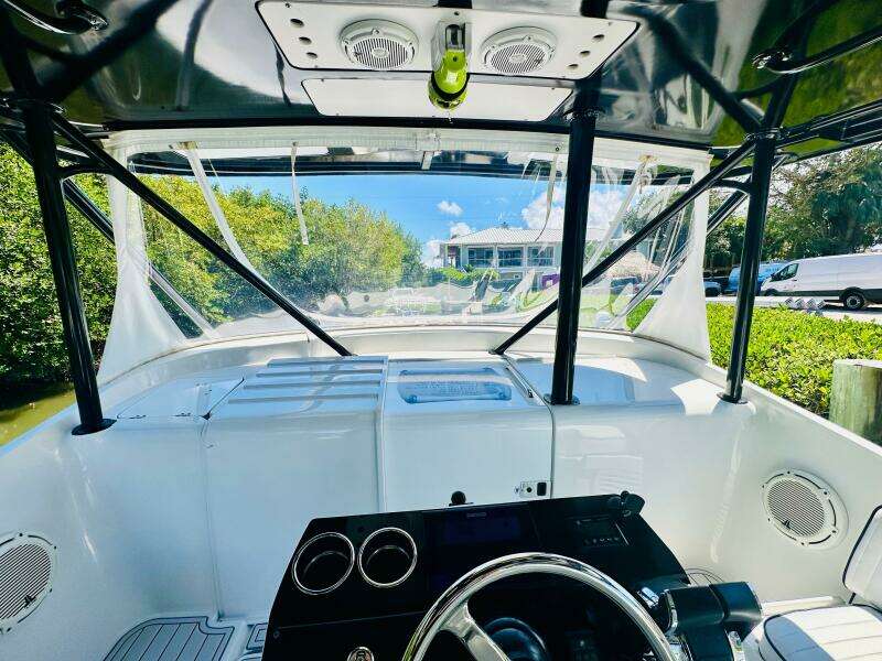 2000 Luhrs Tournament 320 Open boat helm with clear canopy and scenic view.