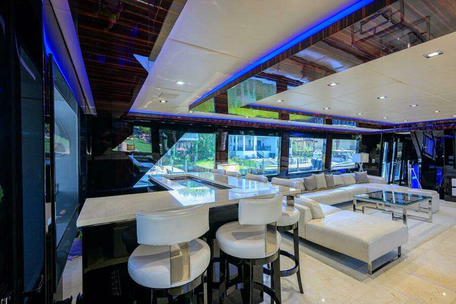 Luxurious interior of 1997 Broward 108 Raised Pilothouse yacht with modern seating and ambient lighting.
