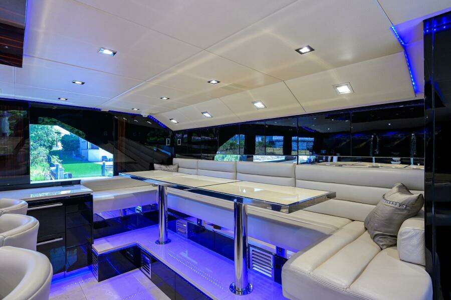 Luxurious interior of 1997 Broward 108 Raised Pilothouse yacht with modern seating and ambient lighting.