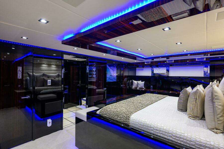 Luxurious bedroom interior of 1997 Broward 108 Raised Pilothouse yacht with modern lighting.