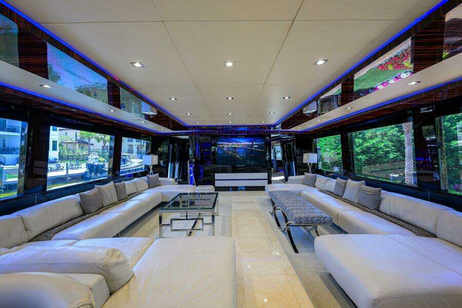 Luxurious interior of 1997 Broward 108 Raised Pilothouse yacht with modern seating and large windows.