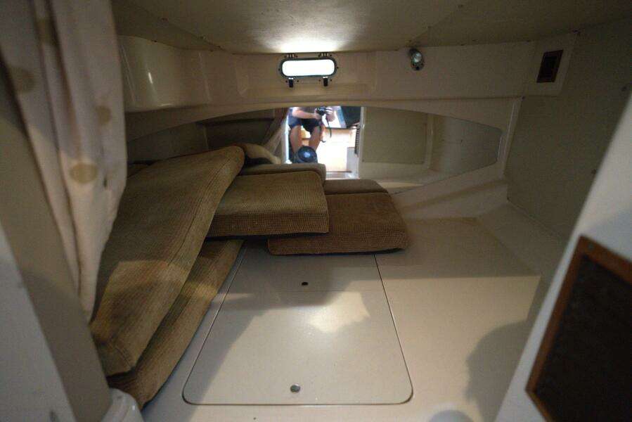 Interior cabin of 2007 Grady-White Express 330 boat with cushions and small window.