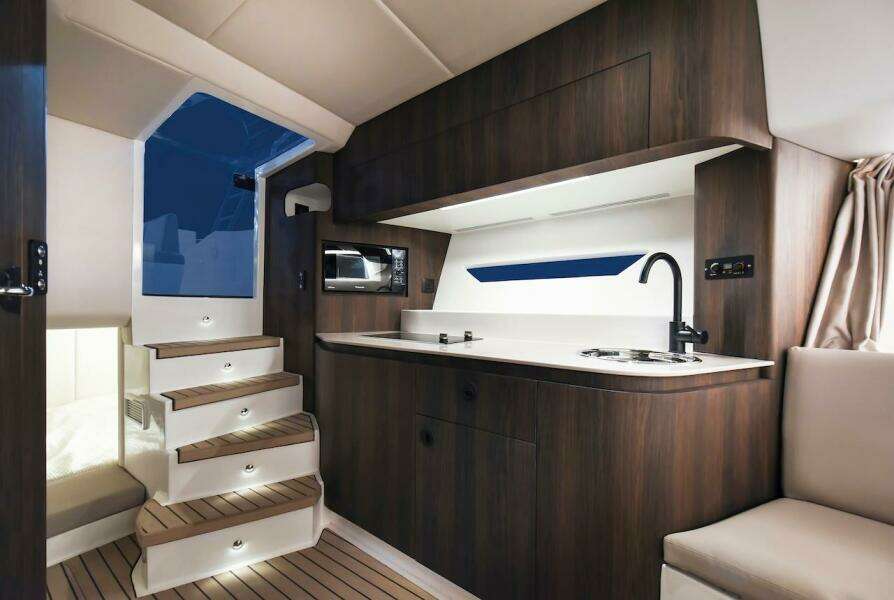2024 Oryx 379 yacht interior with modern kitchen and wooden stairs.