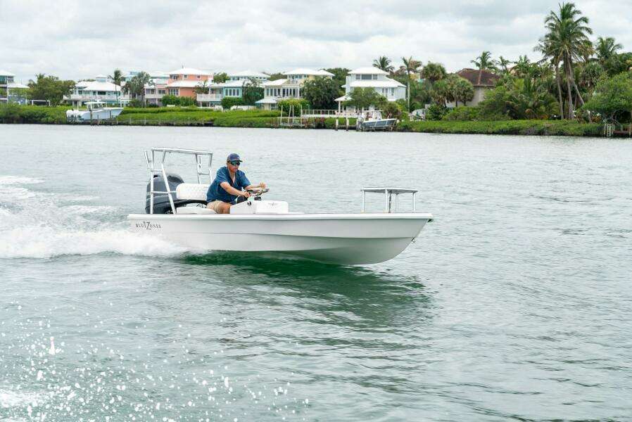 2025 BlueZones Boatworks 16' Flats boat cruising on a scenic waterway.