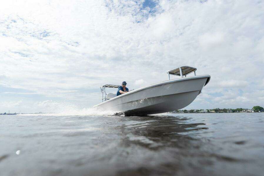 2025 BlueZones Boatworks 16' Flats cruising on open water under a cloudy sky.