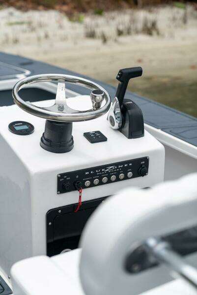 2025 BlueZones Boatworks 16' Flats steering console with controls and steering wheel.