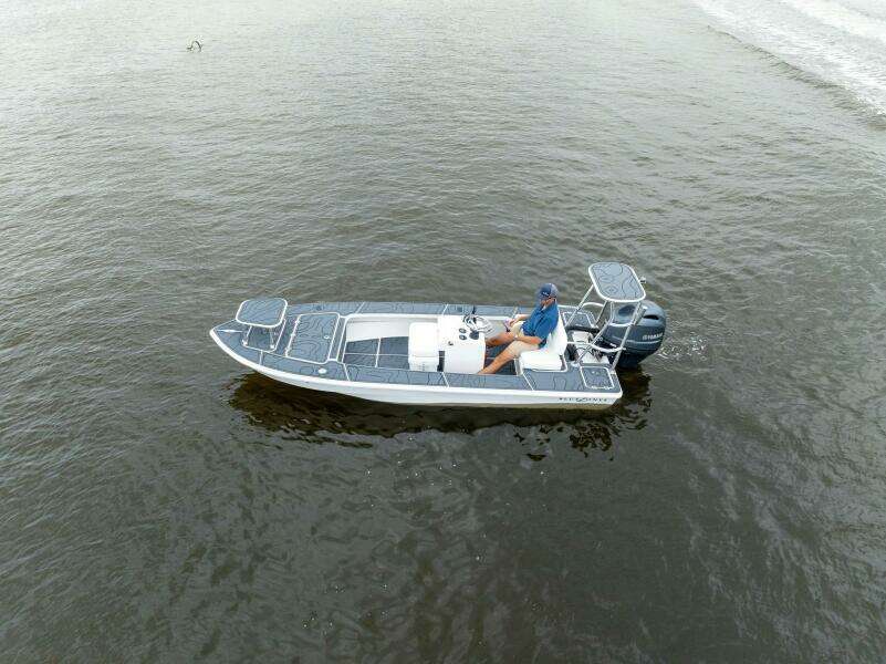 2025 BlueZones Boatworks 16' Flats boat on calm water, aerial view.