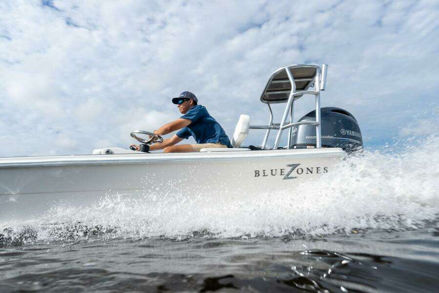 2025 BlueZones Boatworks 16' Flats skiff cruising on water with driver.