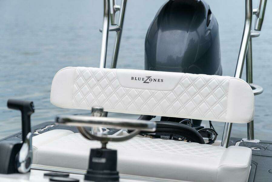 2025 BlueZones Boatworks 16' Flats boat with white quilted seating and motor.