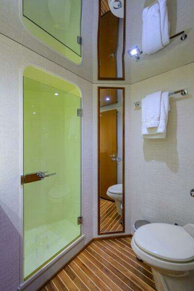 2004 Viking 65 Enclosed Bridge yacht bathroom with shower, toilet, and mirror.