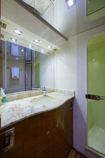 Luxurious bathroom on 2004 Viking 65 Enclosed Bridge yacht with marble countertop and shower.
