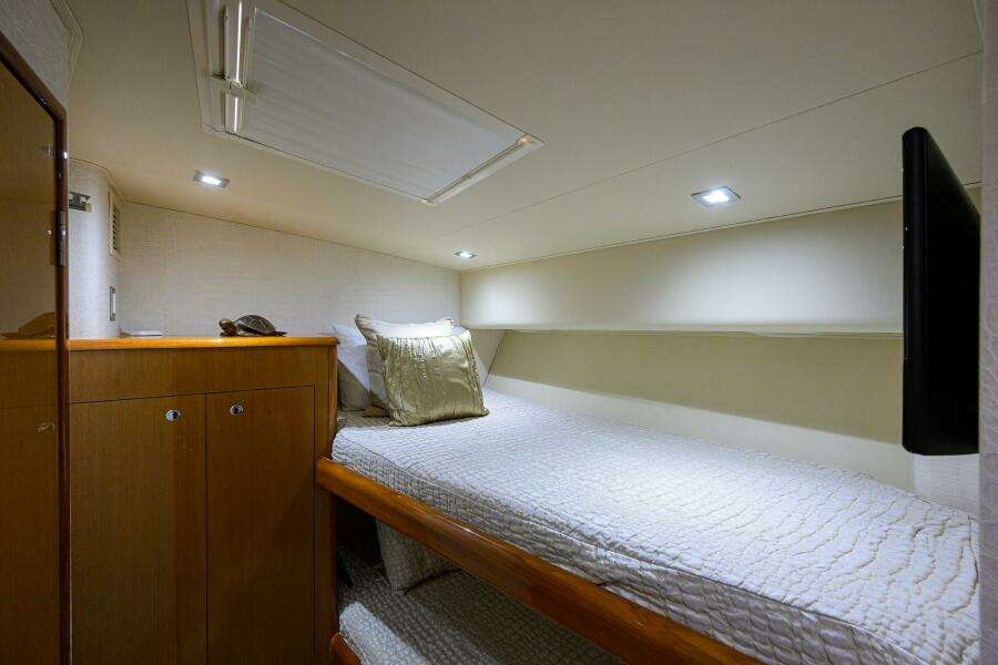 2004 Viking 65 Enclosed Bridge w/Tower cabin interior with single bed and storage.