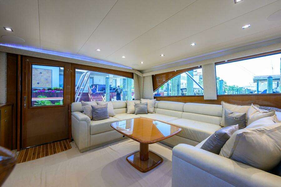 Luxurious interior of 2004 Viking 65 Enclosed Bridge yacht with plush seating and wooden table.