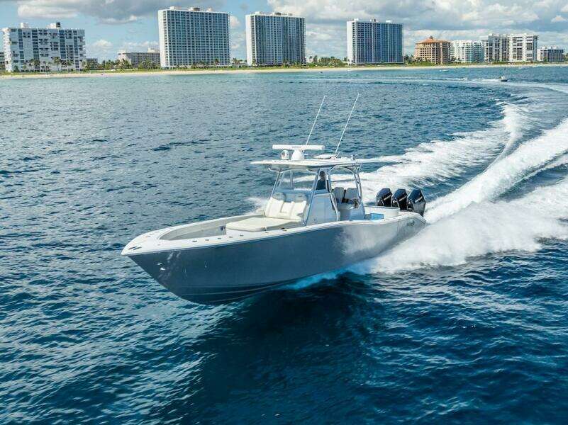 2025 Billfish 39 Center Console boat cruising near coastal city skyline.