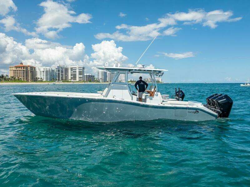 2025 Billfish 39 Center Console boat on ocean, clear sky, cityscape background.