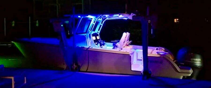 2021 Sailfish 272 CC boat illuminated with blue lights at night.