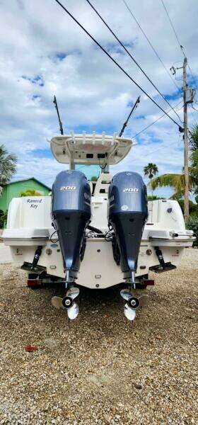 2021 Sailfish 272 CC boat with dual outboard engines, parked on gravel.