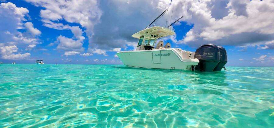 Sailfish 272 CC boat on clear turquoise water under a vibrant blue sky.