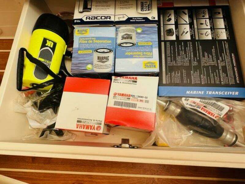 Drawer with marine equipment, Yamaha parts, filters, and a flashlight on a 2014 Grady-White Freedom 335.