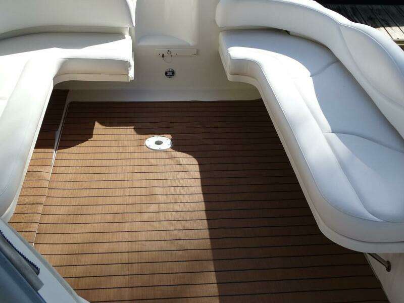 2001 Sea Ray 410 Sundancer cockpit with white seating and teak flooring.