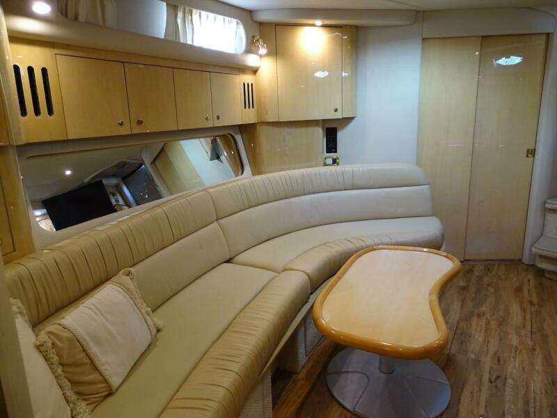 Interior of 2001 Sea Ray 410 Sundancer with beige leather seating and wooden table.