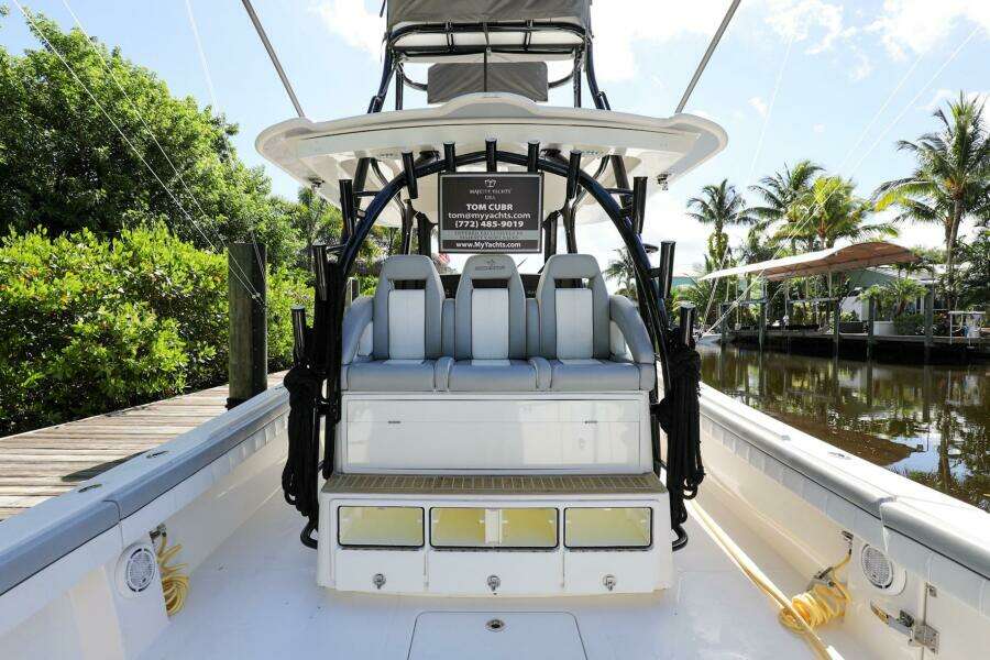 2020 Regulator 41 boat with seating and storage, docked near lush greenery and waterway.
