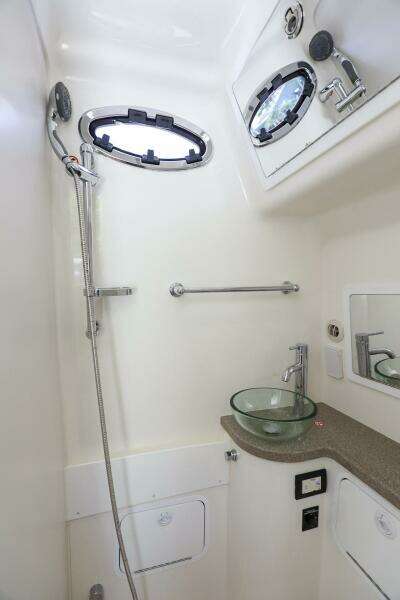 2020 Regulator 41 boat bathroom with shower, sink, and porthole windows.