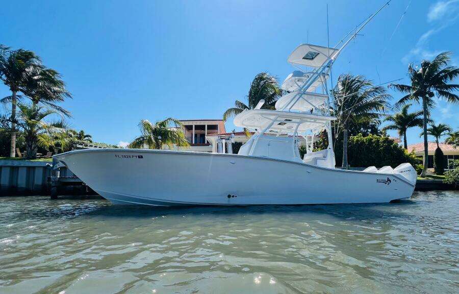 2015 Billfish 39 Custom CC boat docked near palm trees and waterfront homes.