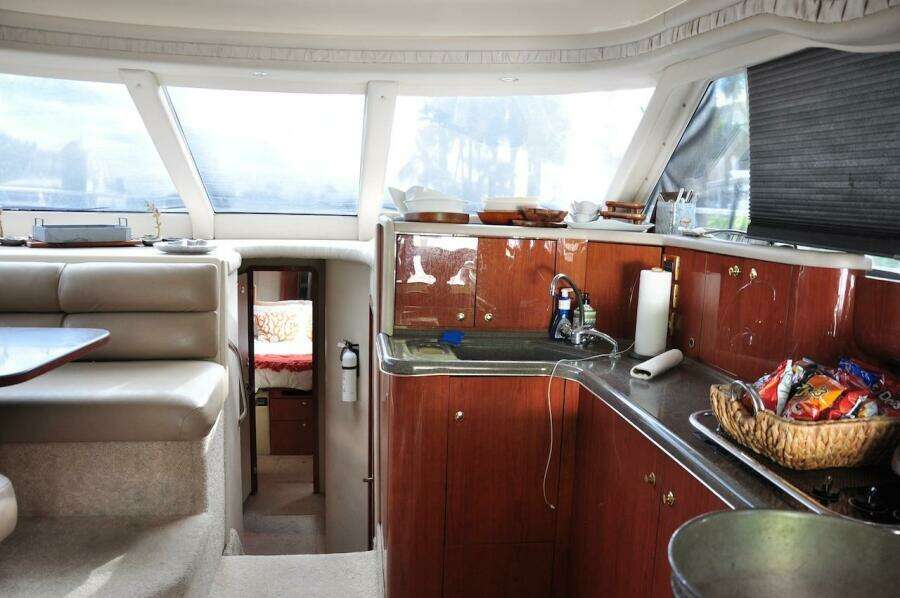 Interior of 1998 Sea Ray 480 Sedan Bridge yacht with kitchen and seating area.