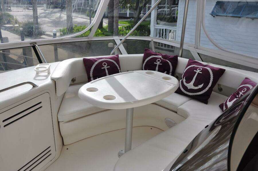 1998 Sea Ray 480 Sedan Bridge yacht interior with white seating and anchor-themed pillows.