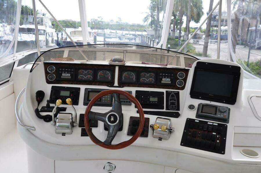 1998 Sea Ray 480 Sedan Bridge helm with steering wheel, controls, and navigation instruments.