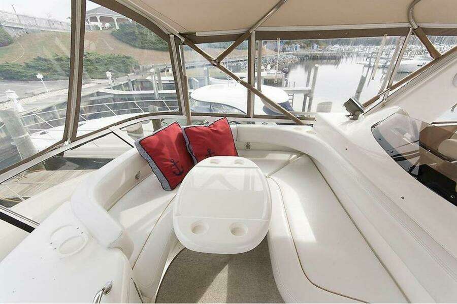 1998 Sea Ray 480 Sedan Bridge interior with white seating and red cushions.