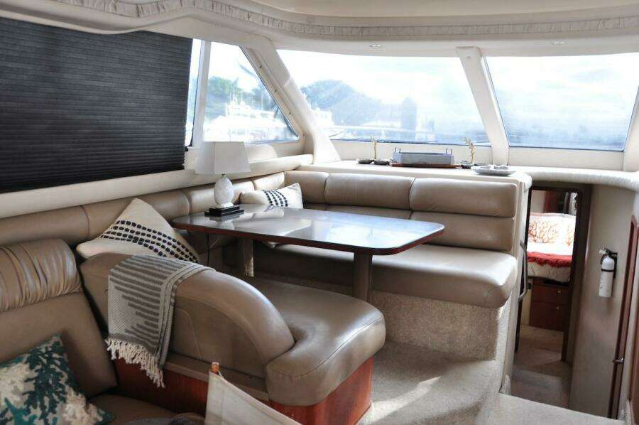 1998 Sea Ray 480 Sedan Bridge interior with leather seating and dining table.