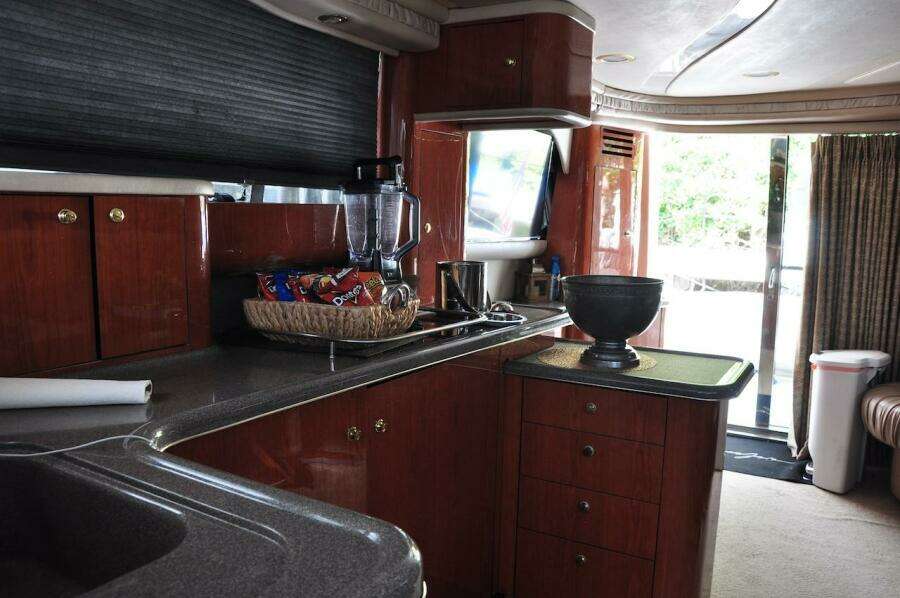 1998 Sea Ray 480 Sedan Bridge kitchen with wooden cabinets and modern appliances.