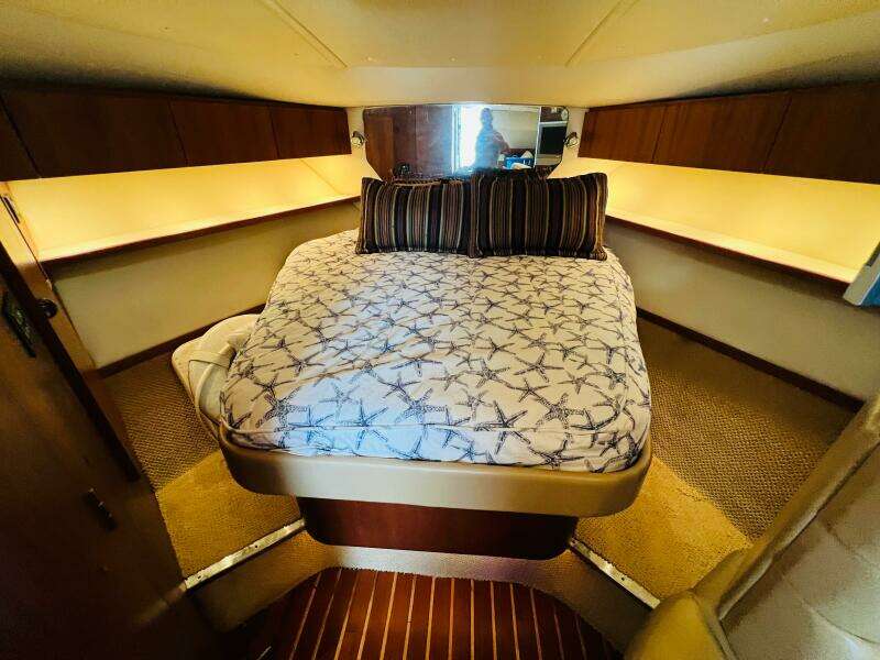 Luxurious cabin interior of 2003 Tiara Yachts 3800 Open with cozy bed and ambient lighting.