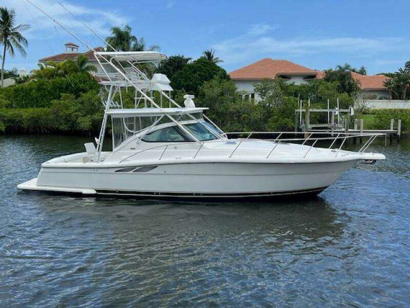 2003 Tiara Yachts 3800 Open boat on calm water, surrounded by lush greenery.